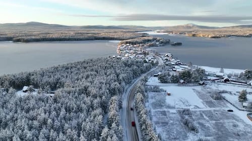 Aerial view of a snowy village peninsula on a frozen lake