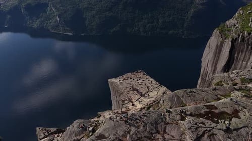 People Hiking at Preikestolen Pulpit Rock in Norway Overlooking Lysefjord