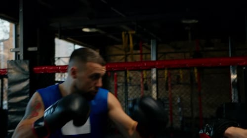 El boxeador practica sus golpes con su entrenador en el gimnasio de boxeo