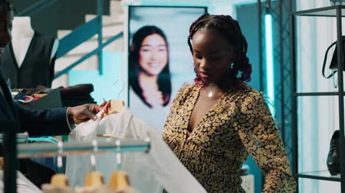 Woman Examining Shirt with Sales Assistant in Boutique