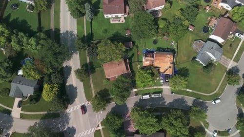 Roofers Installing a New Roof on an Residential Building Wide Aerial Drone Top Down Footage
