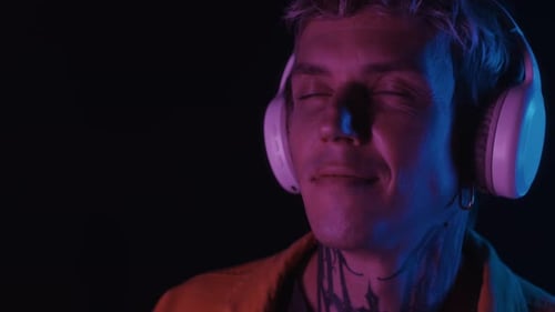 Man Listening to Music with Headphones in Dark