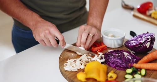 Person Slicing Vegetables on a Cutting Board