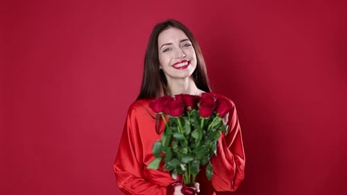 St. Valentine's Day. Beautiful woman with roses on red background