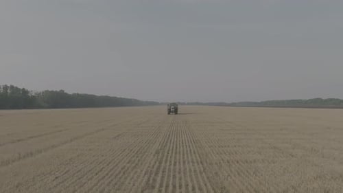 Farmer on Tractor Fertilizing Agricultural Field Spreading Mineral Fertilizer in Slow Motion Tractor