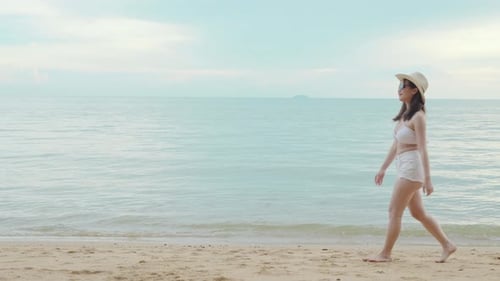 Woman Wear Sungrass and Sunhat Relaxing Walking at Tropical Paradise Beach