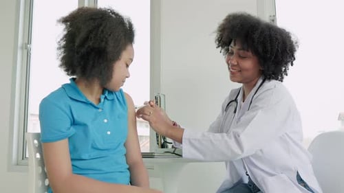 Doctor Giving Teenager a Vaccination in Medical Office