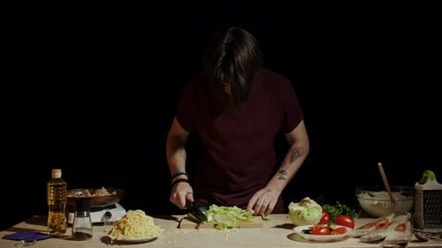 Young Adult Cooking in Dark Kitchen