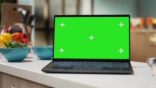 Green Screen on a Laptop Placed on Empty Table in Rustic Kitchen Space