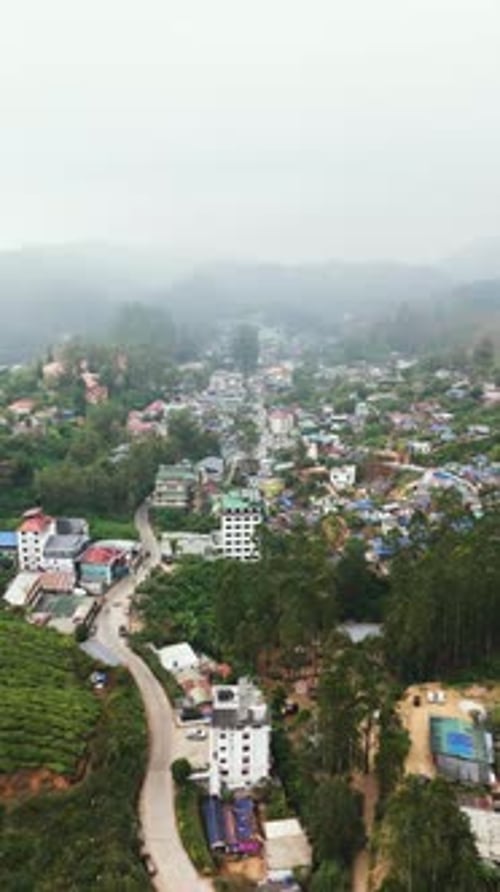Drone vertical filmado em frente a casas coloridas na cidade montanhosa de Munnar, Índia