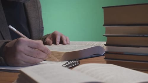 Mann studiert mit Büchern und Notizblock auf dem Schreibtisch, Greenscreen-Hintergrund 4k