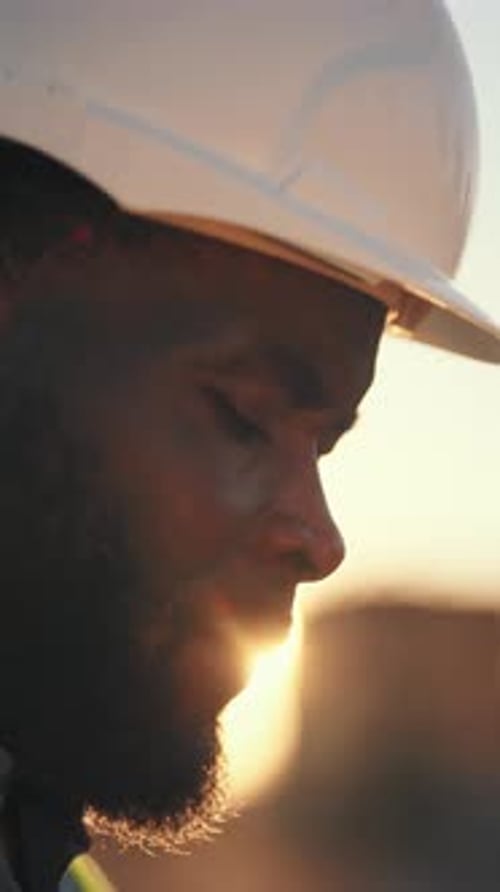 Construction Worker at Sunset wearing Hard Hat and Vest
