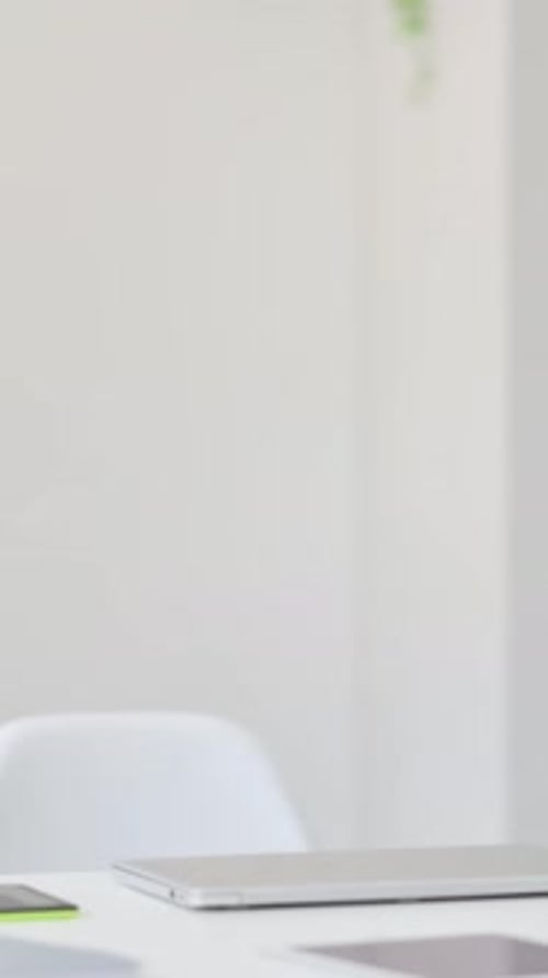 Man Opens Laptop and Begins Typing in Bright Office