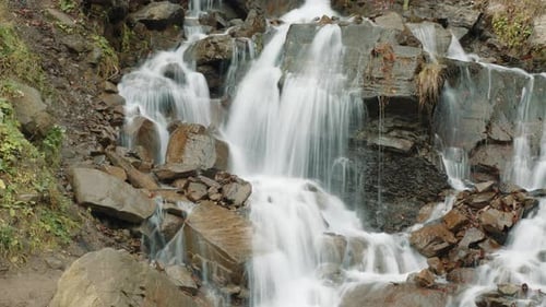 Waterfall Cascading Over Rocks in Lush Nature