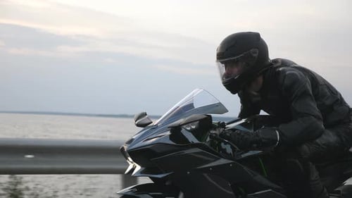 Close Up of Biker Driving Motorbike During Road Trip Near River or Lake
