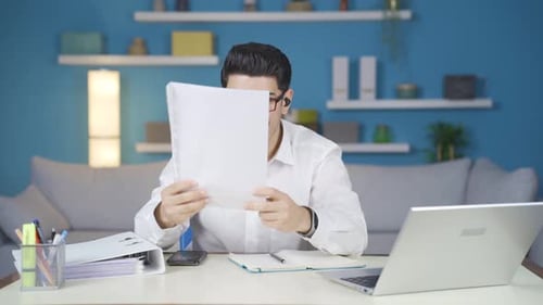 Man Celebrates Business Success at Home Office