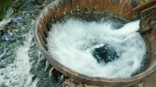 Nahaufnahme von sprudelndem Wasser durch eine Holzrutsche. Die Kraft des Wassers nutzen, um Maschinen zu drehen. Altes Nickerchen