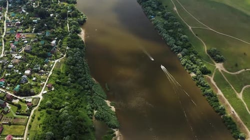 Drone. Fly over the river, country houses. Boats sail along the river. People are swimming. Island