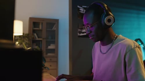 Young Adult Plays Keyboard at Home at Night