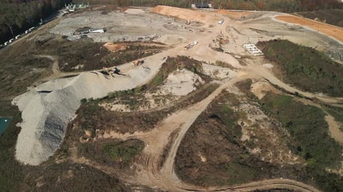 Vue aérienne : camion d'enfouissement des déchets, grue, bulldozer