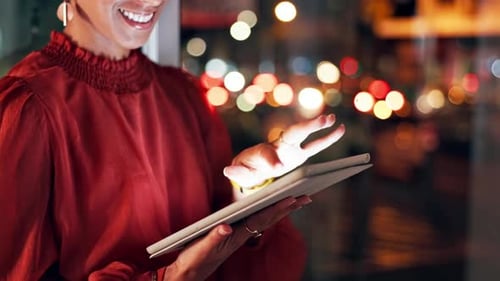 Woman Using Tablet at Night Near Window