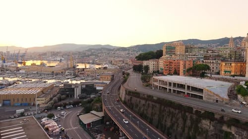 Aerial view of Genoa port, highway, traffic and cityscape at sunset - drone view