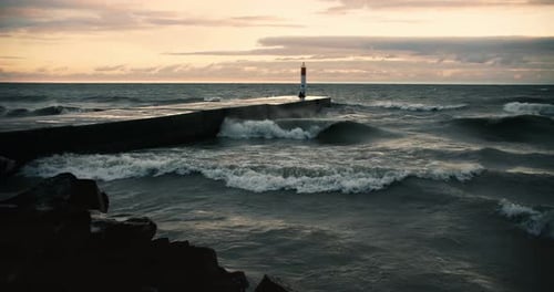 Powerful Storm Waves Crashing against Coastal Shoreline Lighthouse Pier. Ocean Sea Splashing Seashor