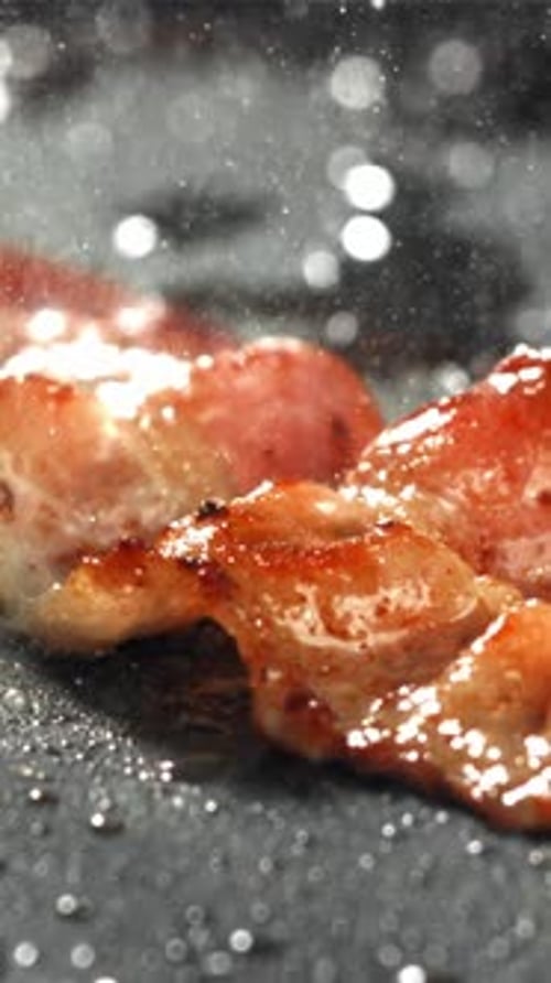 The Bacon is Fried in a Pan with a Splash of Oil Filmed on a Highspeed Camera at 1000 Fps