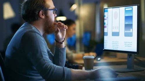 Male Mobile Application Developer Works with Graphics on His Personal Computer with Two Monitors. H