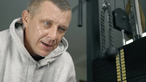 Man Focused on Workout at Gym Using Exercise Equipment for Strength Training