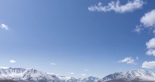 Timelapse of Sun Movement on Crystal Clear Sky with Clouds Over Snow Mountain Top