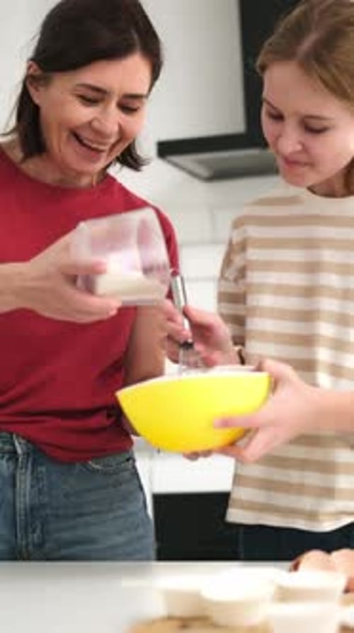 Woman and Teen Girl Baking Together in Kitchen