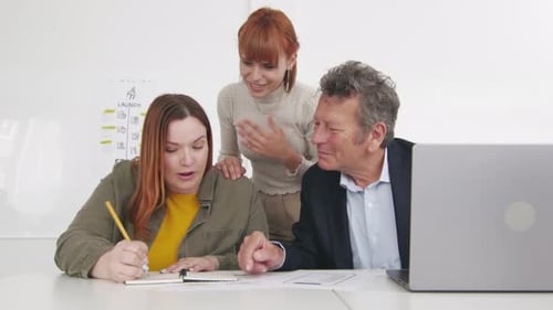 Three professionals engaged in a lively group discussion in a contemporary office, sharing ideas