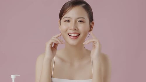 Slow motion close up perfect beauty face of young beautiful Asian woman massages her face gently.