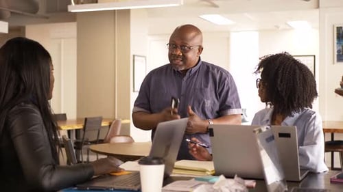 Business People at Laptops Talking Planning in Office Meeting 2529 Years