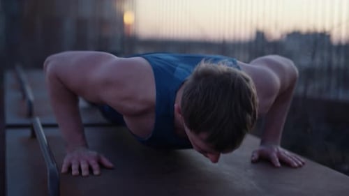 Muscular Man Doing Pushups Outdoors at Golden Hour