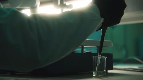 Working with chemical elements. Stock footage. Green medicine in test tubes with working scientists