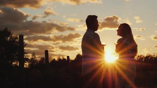 A Romantic Couple Drinks Wine at Sunset in a Picturesque Place Wine Tour Concept