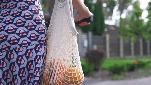 Una mujer monta un scooter eléctrico alquilado después de comprar en una tienda