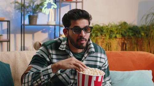 Man Enjoys Movie Night with Popcorn at Home