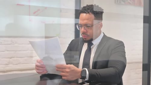 Man Reviews Documents in Modern Office