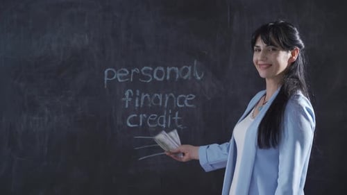 The woman who writes Consumer Loans on the blackboard looks with a happy expression.