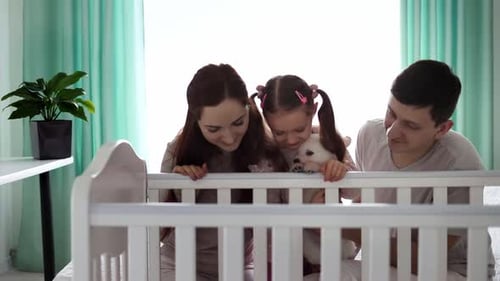 Happy Family with Dog Near Baby Crib