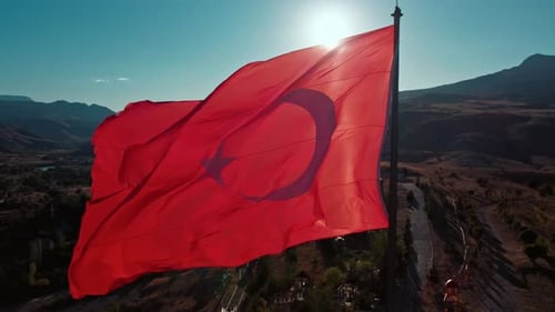 Red Flag Waving Proudly in Rural Landscape