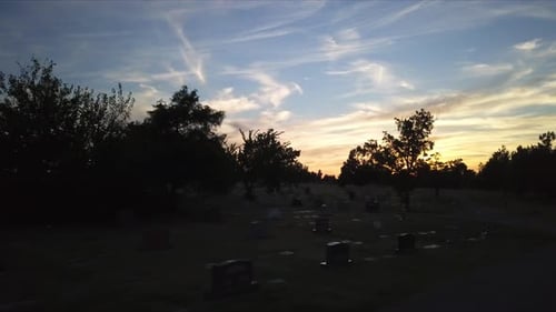 Aerial view through cemetery over gravestones during sunrise golden hour