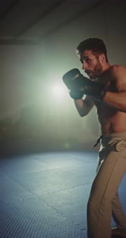 Shirtless Man Boxing in an Urban Gym