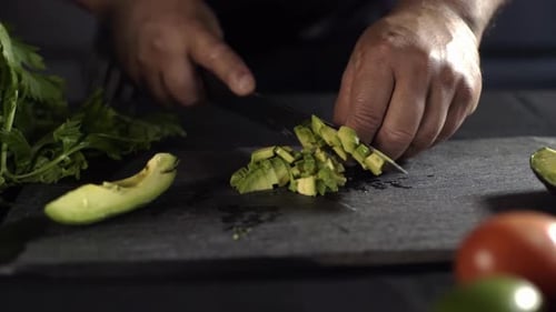Close Up A Chef cuts an avocado into small pieces with a sharp knife