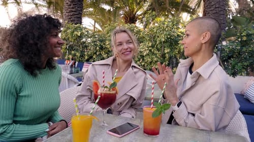 Friends Enjoying Drinks and Conversation at Outdoor Cafe