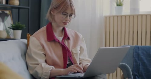 Woman Working on Laptop at Home on Couch