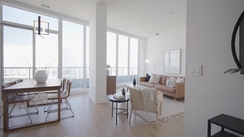 La foto número 1 de gran angular muestra el comedor y la sala de estar de un condominio tipo ático con techos altos